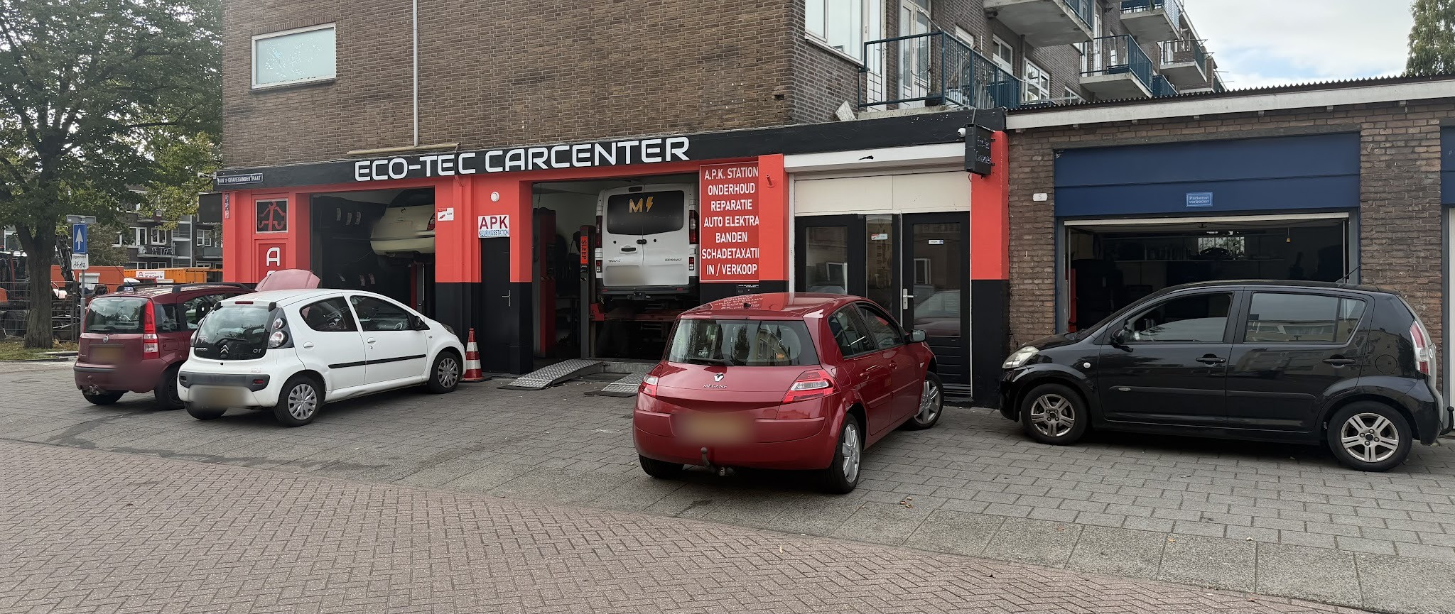 Auto's voor de open garagedeur van Eco-Tec Carcenter, met een bestelbus op de brug